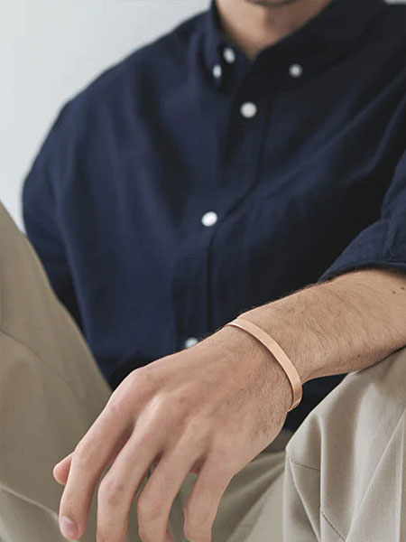カジュアルな服装の男性の手元をアップで写し、ブレスレットの質感と馴染み方が分かる画像。