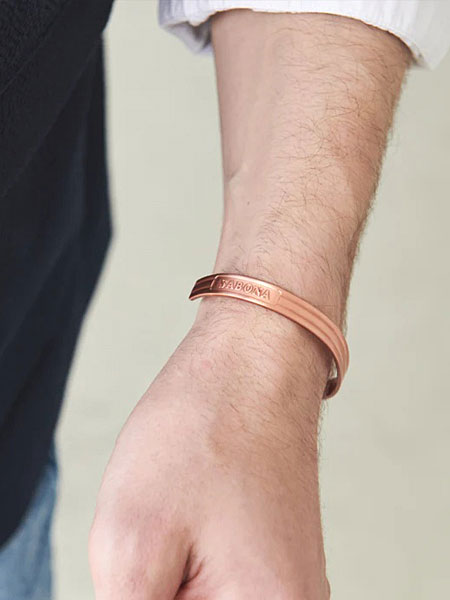 男性の手元をアップで写し、ライン入りデザインが腕元に自然に馴染む様子が分かる着用画像。