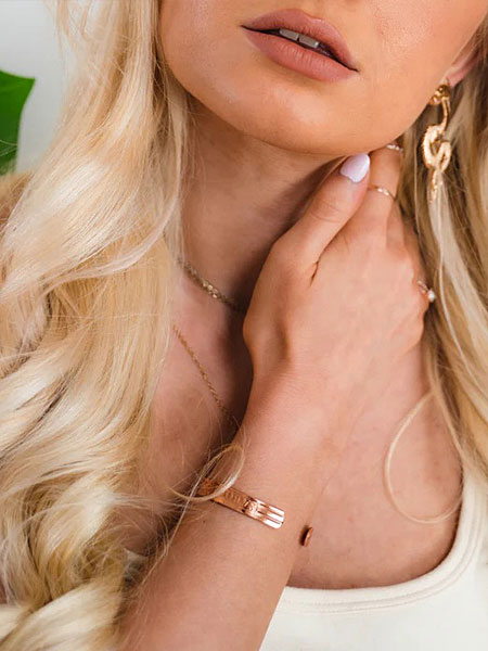 開口部をフロントにして着用した女性の手元を写し、デザインの見え方が分かる画像。