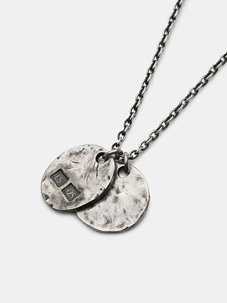 ハンドメイド感のある凹凸と深い燻し加工が施されたペンダント裏面を写したアップ画像。