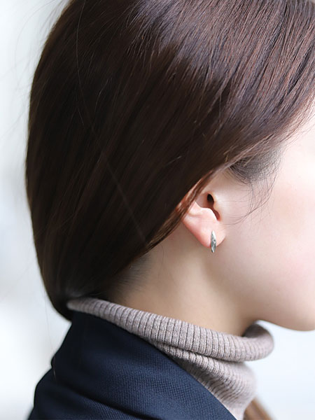 ワイズマンピアスを女性が着用している様子で、ロジウムコーティングのシルバーが耳元でさりげなく光る画像。