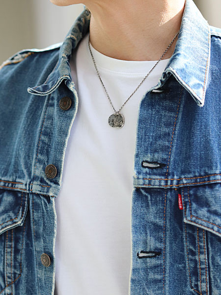 ダブルプレートネックレスを男性が着用しており、ボタニカルペイズリー柄の重なりが胸元で静かに映える画像。