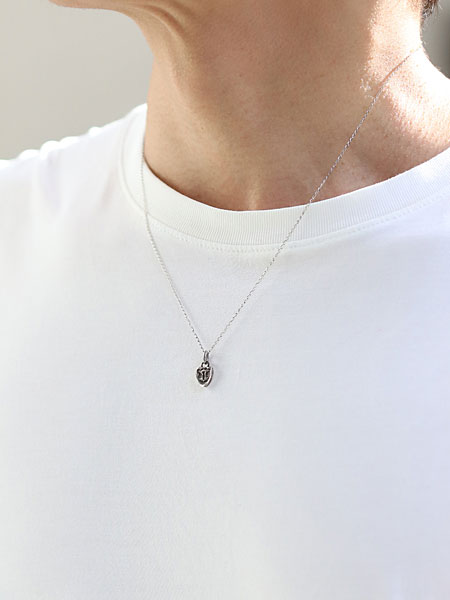 ピジョン チャーム ペンダントを男性が着用し、鳩モチーフが胸元で落ち着いて映える画像。