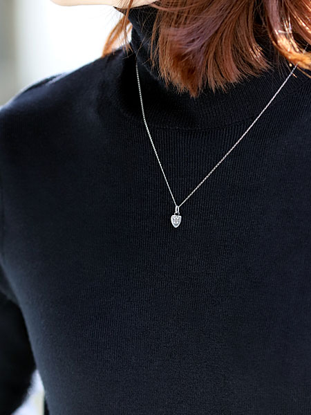 ピジョン チャーム ペンダントを女性が着用しており、鳩モチーフが首元でさりげなくなじむ様子が分かる画像。