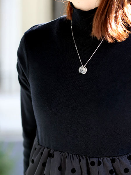 女性が着用している様子で、ダブルプレートネックレスの繊細な柄と程よいサイズ感が首元になじんでいる画像。