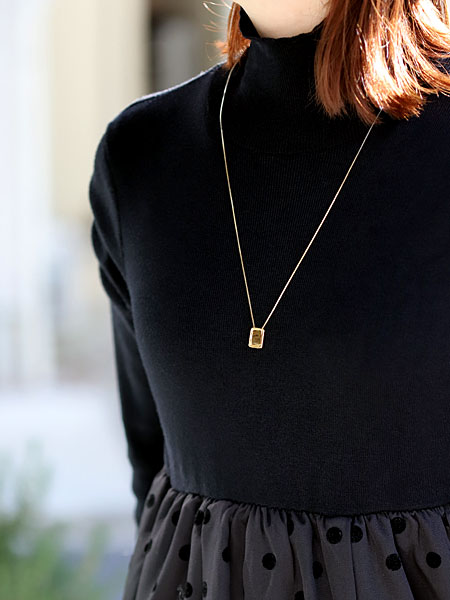 女性がゴールド側を表にして着用している様子で、エスカプラーリオネックレスのやさしい光沢が首元になじんでいる画像。