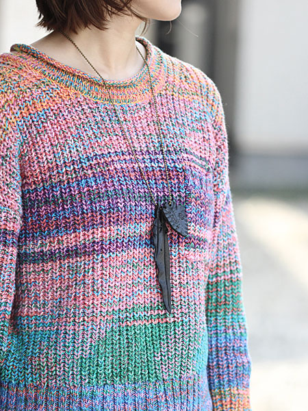 ニットスタイルの女性が着用しており、レザーフェザーがコーデのアクセントになっている画像。