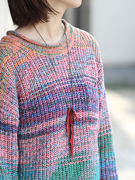 ニットスタイルの女性が着用しており、レザーフェザーがコーデのアクセントになっている画像。