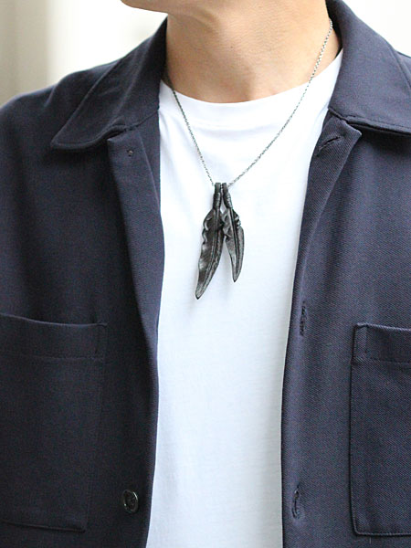 50cmチェーンで首元にすっきり収まるレザーフェザーネックレスを男性が着用し、サイズ感が分かる画像。