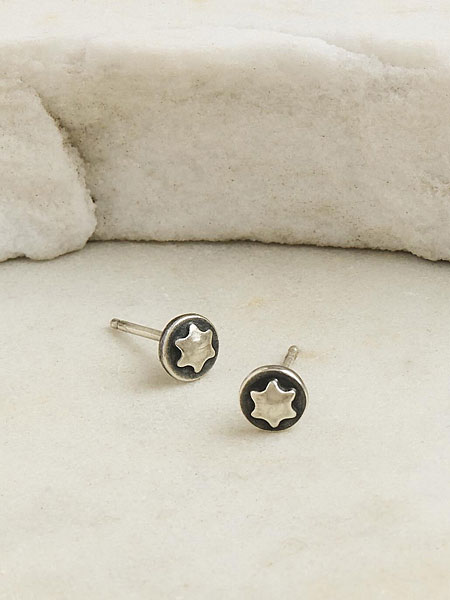 白地の上に置き、シルバーの質感と小ぶりなサイズ感が伝わるピアスのディスプレイ画像。