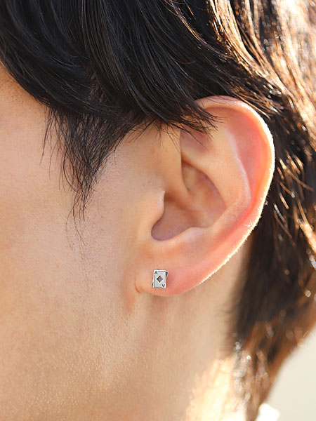 男性の耳元にトランプモチーフのスタッドピアスを着用している様子で、程よいサイズ感が分かる画像。