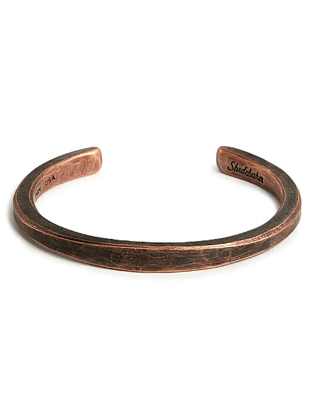 正面から見たバングルの画像で、厚みのあるシルエットとミニマルなデザインが伝わります。