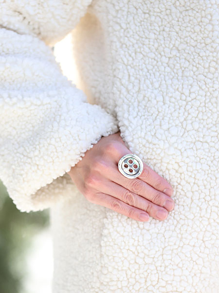 ボタンリングを着用した女性が腰に手を当てた状態を正面から写した画像で、コーディネートとのバランスが分かります。