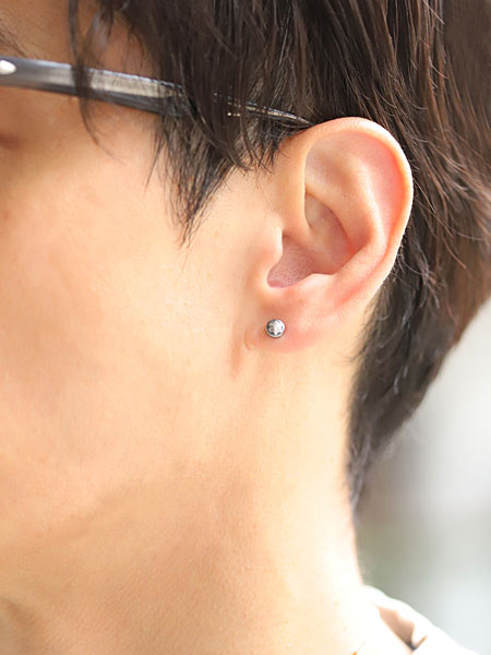 男性が着用したスタッズピアスの着用イメージで、程よい存在感が耳元にさりげなく映えています。