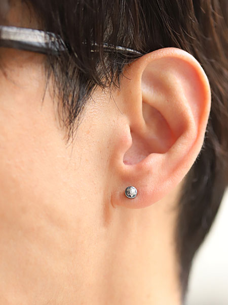男性の耳元をアップで撮影したピアスの着用画像で、無骨な質感と立体感がよく分かります。