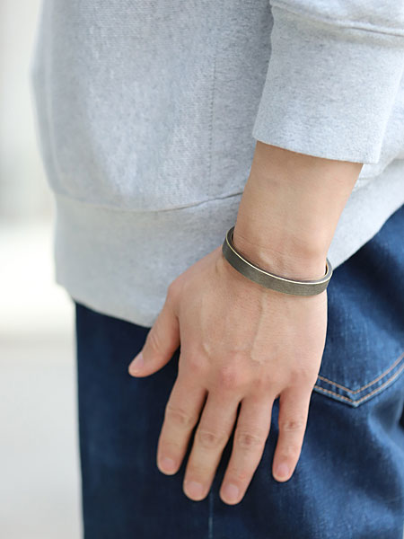 男性の手元を横から撮影したバングル着用画像で、厚みとカーブのラインがよく分かります。