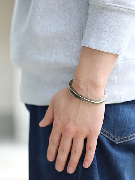 男性の手元を横から撮影したバングル着用画像で、厚みとカーブのラインがよく分かります。