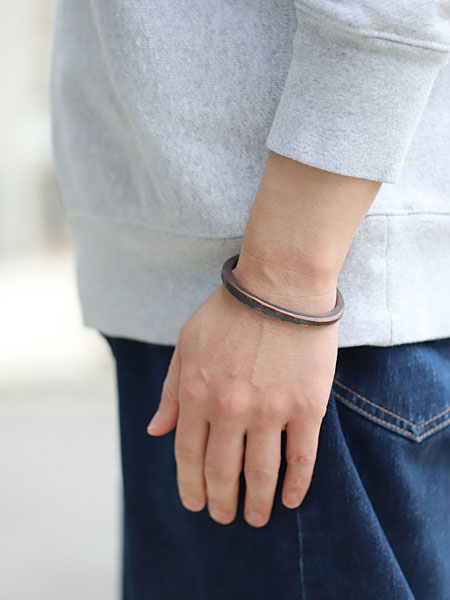 男性の手元を横から撮影したバングル着用画像で、厚みとカーブのラインがよく分かります。