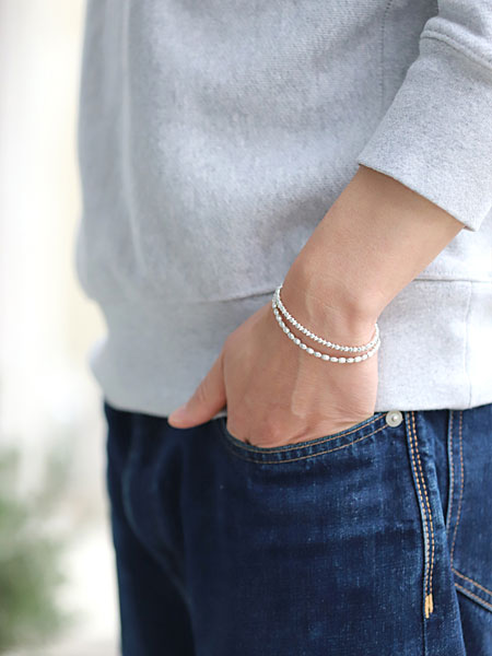 スウェットとジーンズスタイルに合わせ、横から写したブレスレット着用イメージ。