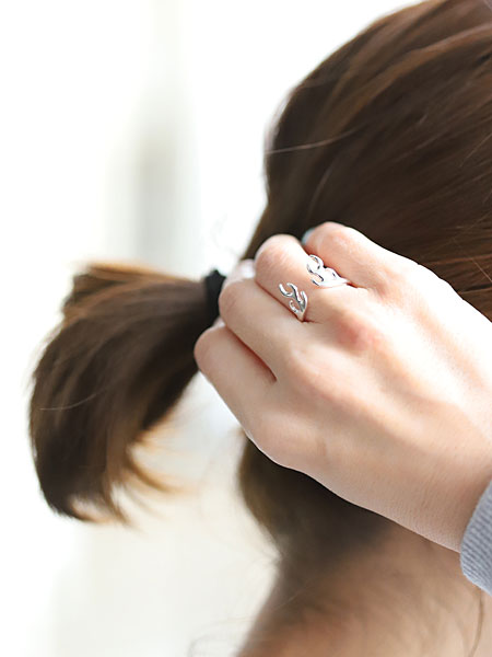 髪に手を添えた女性の指もとで、鹿の角リングがさりげなく映える着用シーンの画像。