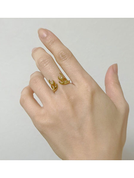 中指に鹿の角モチーフのリングを着けた手元をアップで写した着用画像。