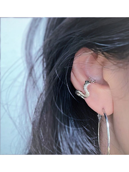 大きめのフープピアスと白蛇イヤーカフを合わせた女性の着用コーディネート画像。