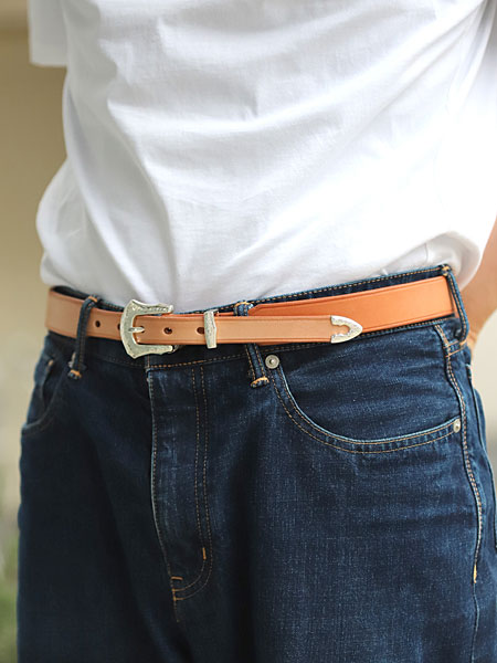 白Tシャツとジーンズにナチュラルレザーのウエスタンベルトを合わせた男性の着用画像で、カジュアルなスタイリングがよくわかります。