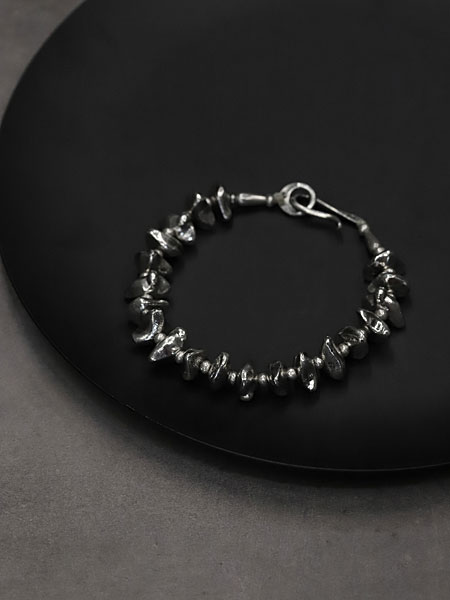 黒い丸い台の上に置いた大きめシルバービーズブレスレットのディスプレイ画像。