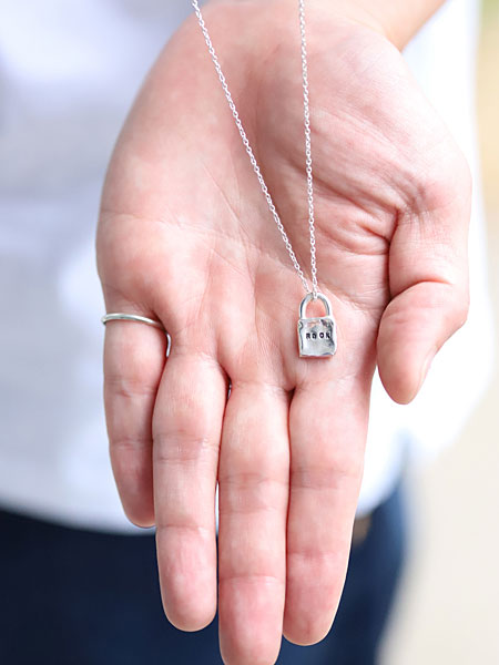 ペンダントトップを手のひらに乗せて写した、小ぶりで上品なサイズ感がわかるネックレスの画像。