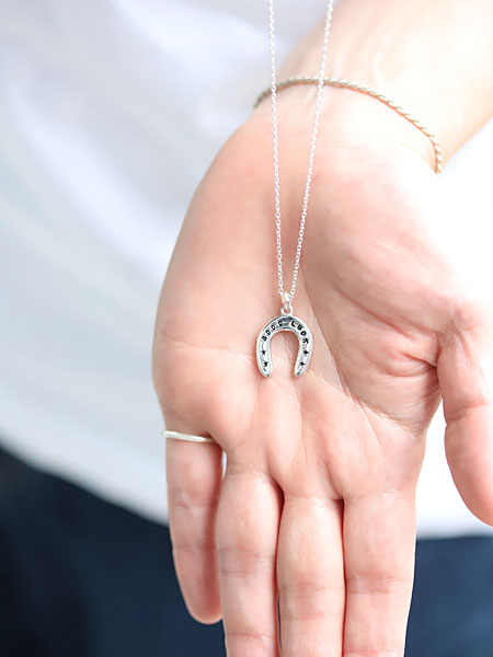 ペンダントトップを手のひらに乗せて写した、小ぶりで上品なサイズ感がわかるネックレスの画像。