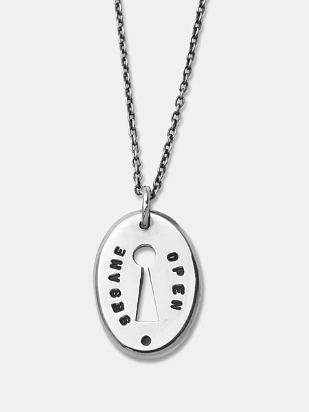 キーホールモチーフのペンダントトップを正面から写した、刻印の雰囲気とデザインがしっかり伝わる画像。