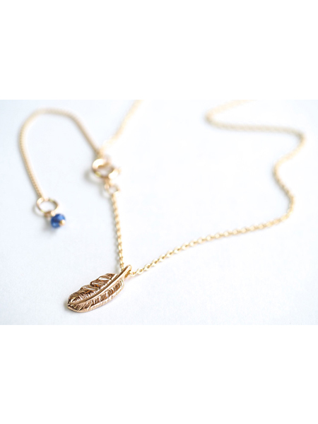 フェザートップとチェーンエンドのサファイアチャームを写した、ゴールドの上品な輝きとアクセントが楽しめるディテール画像。