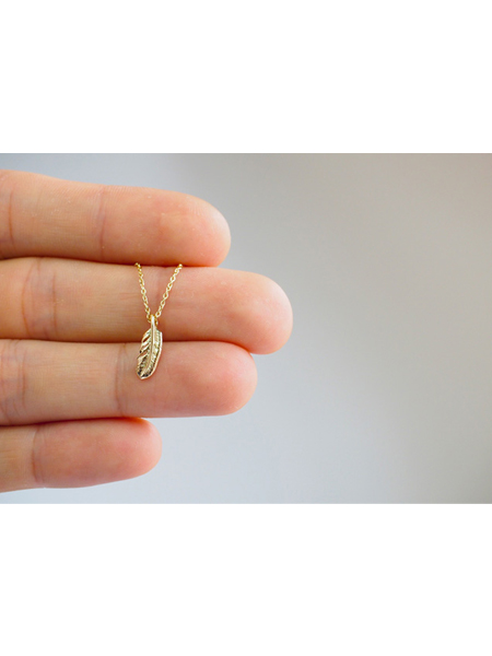小さなフェザートップを手のひらにのせた、上品でデイリーに使いやすいサイズ感が伝わるネックレスのイメージ画像。