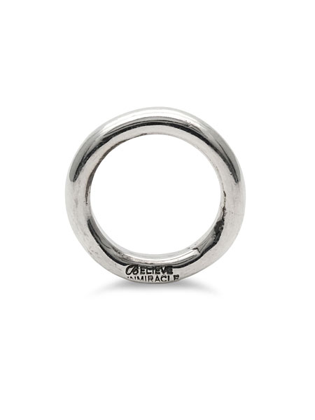 リングを立てて正面から写し、ラフに打ち込まれたBELIEVEINMIRACLEの刻印がさりげないアクセントになっている様子。