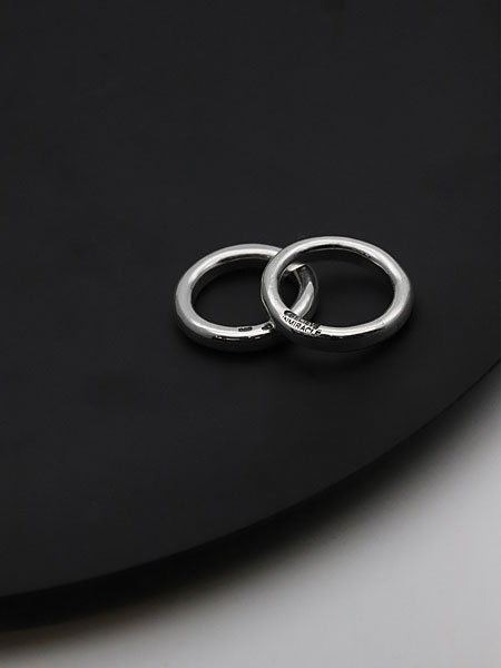 黒い円形の台にサイズ違いのリングを重ねて置き、無骨さと上品さが共存するディスプレイイメージ。