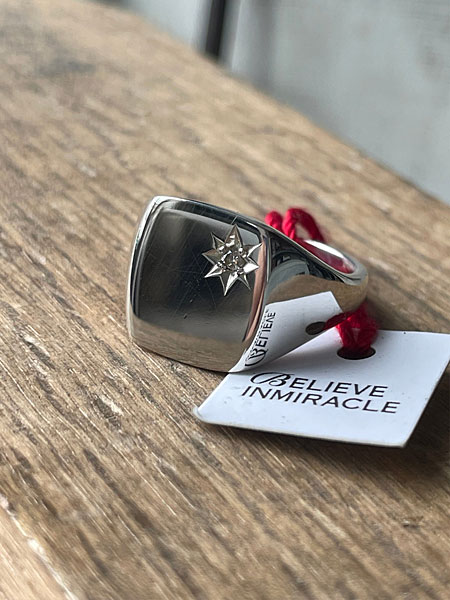 黒い円形の台にサイズ違いのリングを重ねて置き、無骨さと上品さが共存するディスプレイイメージ。