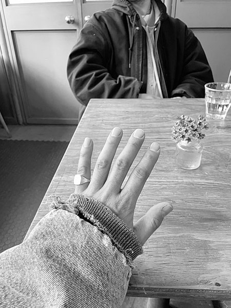 小指に着用したリングのモノクロ写真で、質感やフォルムの美しさが際立つ雰囲気のあるカット。