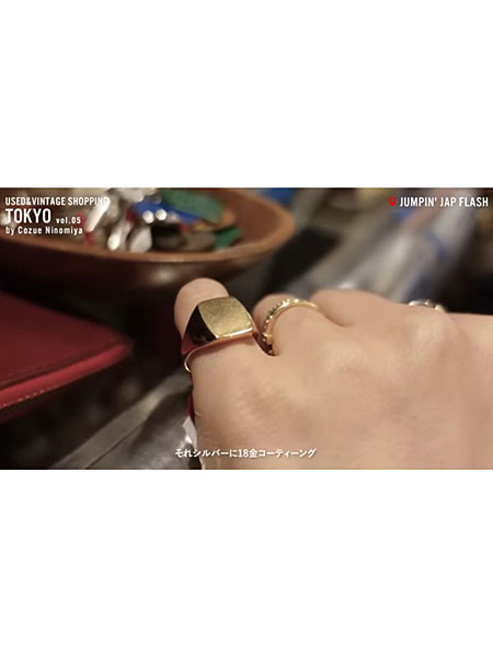 二宮こずえさんが小指にシグネットリングを着用し紹介しているシーンのカットで、リアルなサイズ感が伝わる一枚。