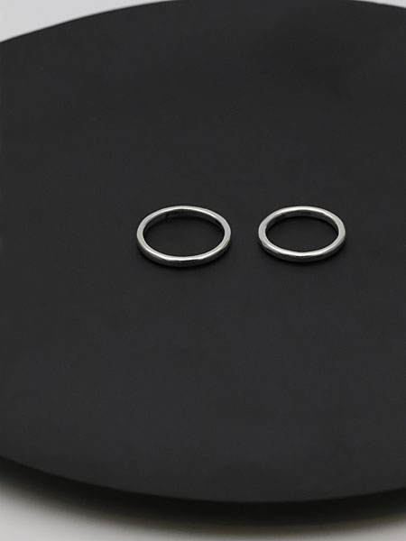 黒い丸い台の上にサイズ違いで並べられた2本のリングで、シンプルなデザインとペア使いの雰囲気が伝わるカット。