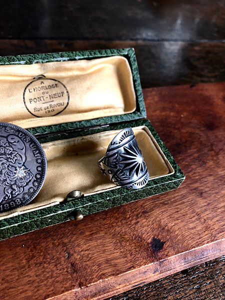 雰囲気のあるボックスの中にディスプレイされたリングが、落ち着いた空気感で撮影されたイメージ画像。