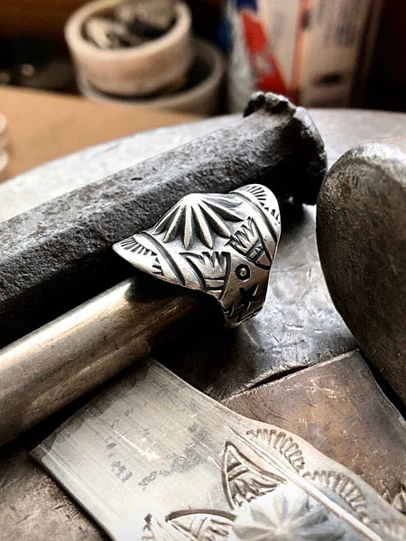 完成したリングが工具とともに置かれ、アトリエの空気感が感じられる雰囲気あるイメージカット。