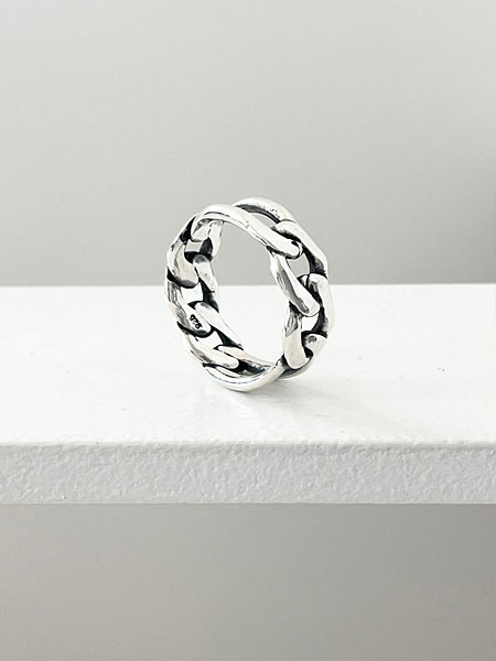 白い台の上にリングを立ててディスプレイし、シルエットとチェーンの立体感が際立つイメージ画像。