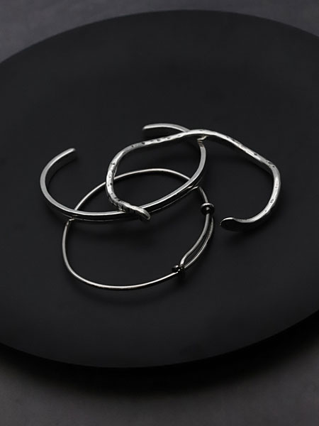 黒い丸い台の上で別作品のブレスレットと重ねて置かれた、重ね付けの雰囲気が伝わるディスプレイ画像。