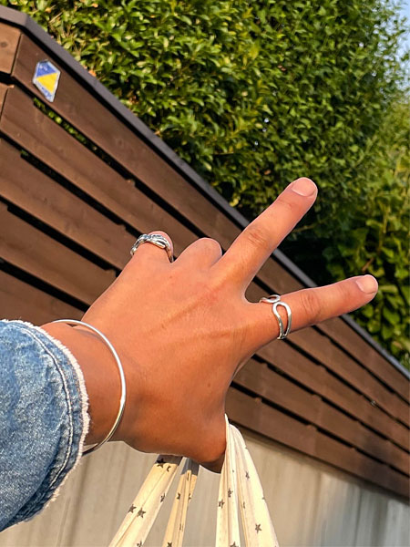 ピースサインをした手元にワイヤーブレスレットを着用した、ラフな雰囲気のスタイリングカット。