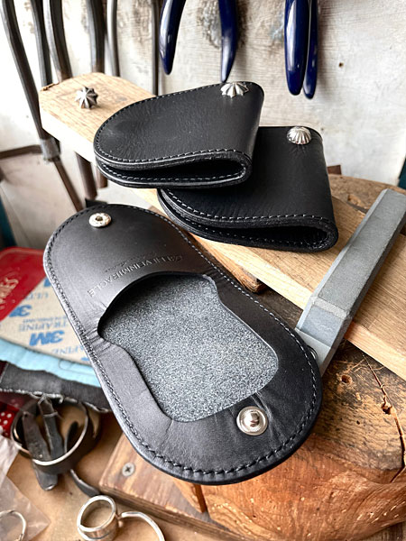 完成したコインケースが並べられたアトリエの制作風景を写し、ハンドメイドの雰囲気が伝わる画像。