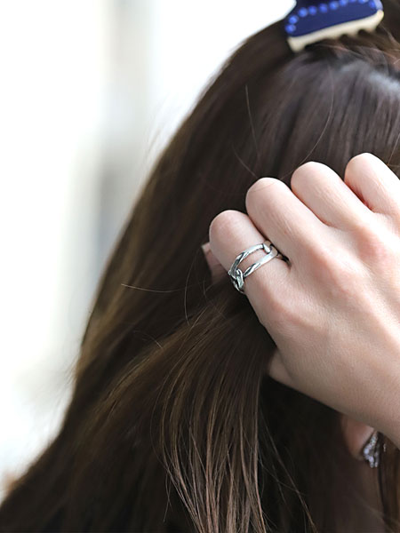髪をかき上げる仕草の女性の手元アップで、幅のあるチェーンリングが自然に視線を引きつける着用画像。