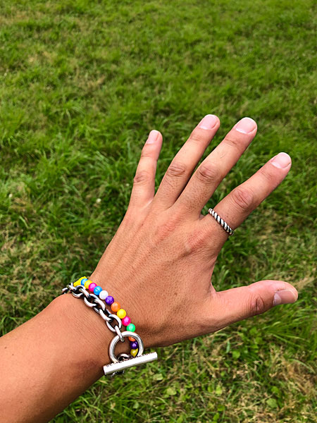 シルバーのブレスレットやリングと合わせて着用した、カラフルなビーズブレスレットのバランスが分かる手元画像。