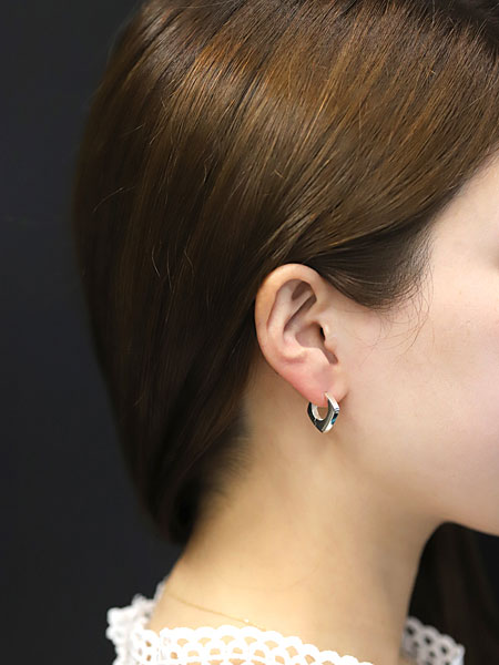 女性の耳元でスクエアフラットフープピアスが艶やかに輝き、上品で洗練された印象を演出する着用画像。