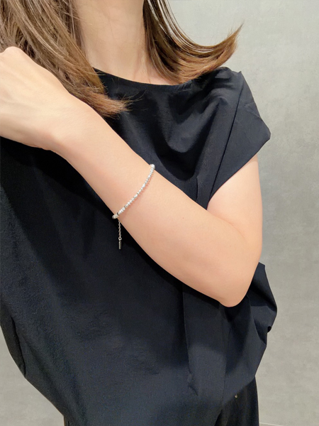 シャープなソロバンビーズと丸みのあるオーバルビーズが絶妙なアクセントになった、女性の着用イメージ。