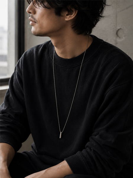ロングシルエットのネックレスが男性の胸元に自然なVラインをつくり、リラックス感を添える着用画像。